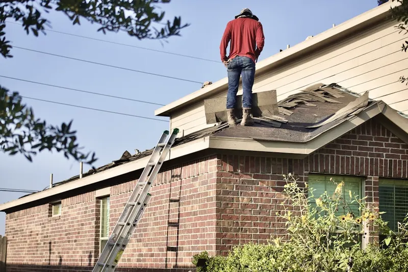 Professional roofer working on a residential roof in Madrillon Farms